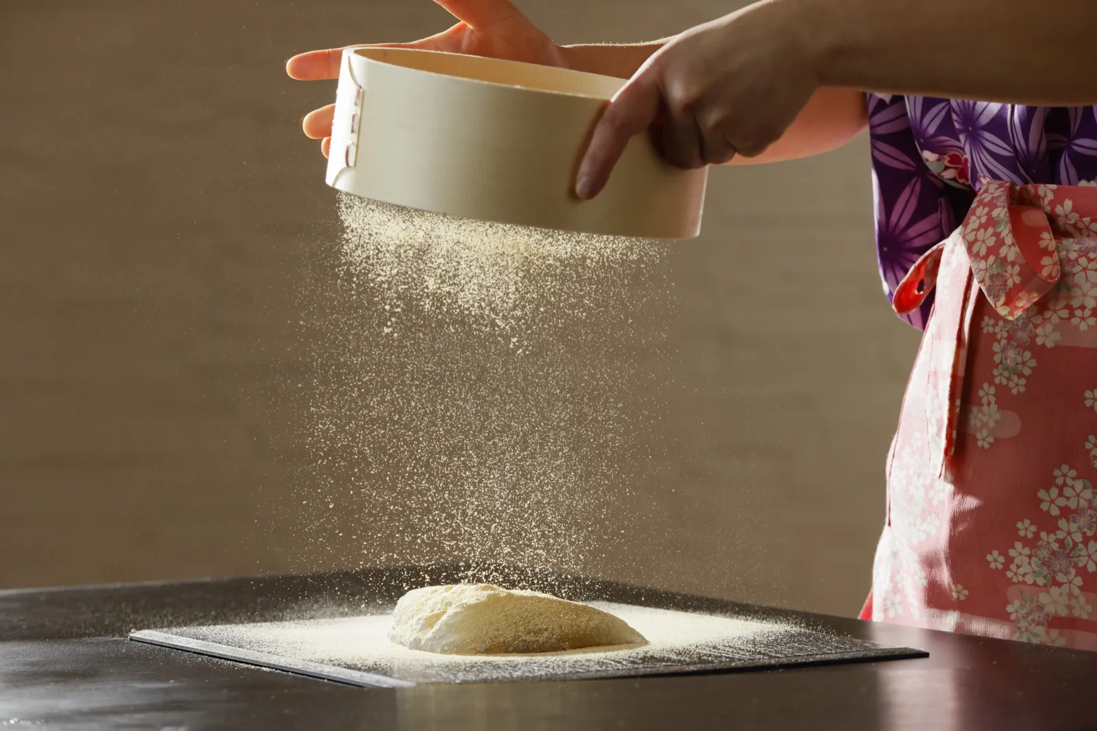 Kinako being sifted over freshly made warabimochi