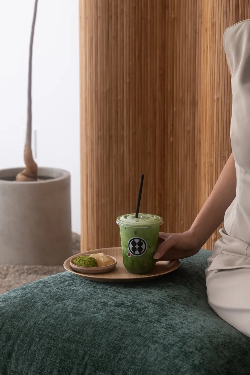 Iced matcha drink and warabimochi served on a wooden tray